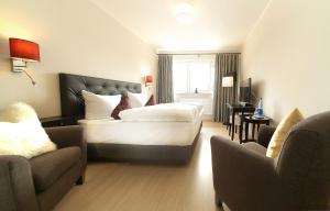 奥斯赛拜-屈隆斯博恩Wittenbeck Resort的酒店客房,配有一张床和两把椅子