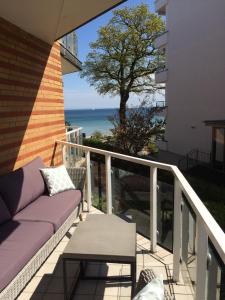沙博伊茨Strandperle 5的阳台配有沙发,享有海景。