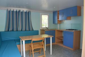 代穆斯冒险海滩露营地的厨房配有蓝色橱柜和木桌