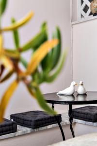 提诺斯Aleka's Rooms的两只白鸟坐在植物旁边的桌子上