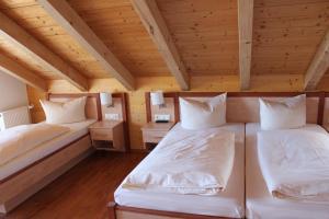 埃尔森贝格加斯托夫克拉麦维特酒店的配有木天花板的客房设有两张床。