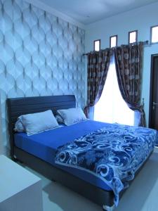 普卡希阿利亚扎姆扎姆别墅假日公园的一间卧室配有蓝色的床、蓝色的被子和窗户