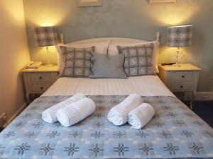 阿伯里斯特威斯Gwesty'r Marine Hotel & Spa的一间卧室配有一张床,上面有两条毛巾