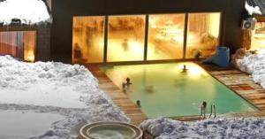 拉斯莱尼亚斯维戈酒店&Spa的一群人在雪地中的游泳池里