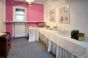 科林本森伯德威姿酒店的粉红色墙壁的房间的一排桌子