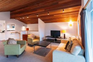 圣奥斯特尔康沃尔Spa和小屋酒店的客厅配有沙发、椅子和电视