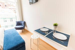 波尔图Porto 271 Mouzinho Apartamentos的客厅配有桌子和蓝色沙发