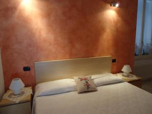 切尔诺比奥La Cà in piaza的一间卧室配有一张带两盏灯的大型白色床。