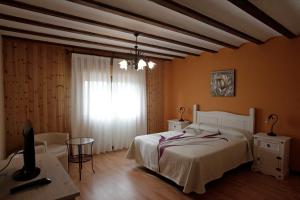 Matute de la SierraCasona Santa Coloma的一间卧室配有一张床、一张桌子和一个窗户。