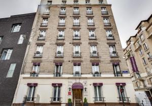 巴黎贝勒弗巴黎北车站酒店的一座高大的砖砌建筑,设有窗户和门