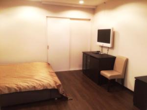 大阪马加达酒店（仅限成人）的一间卧室配有一张床和一张书桌及电视