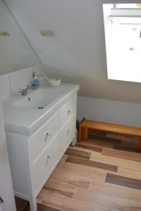 KamminkeHaus Betty的铺有木地板,设有带白色水槽的浴室