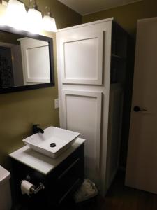 科迪Secret Cottage Yellowstone 1 bd 2 beds dtwn #1的浴室设有白色水槽和镜子