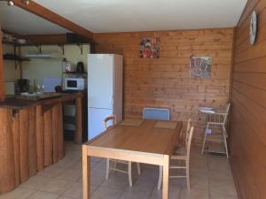 拉卡诺chez steph&aurore的厨房配有木桌和冰箱。