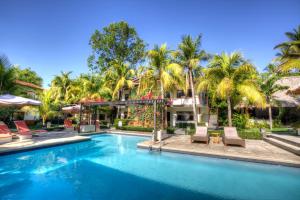 拉利伯塔德博卡欧拉度假酒店的棕榈树屋前的游泳池