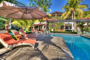 拉利伯塔德博卡欧拉度假酒店的房屋旁的游泳池配有椅子和遮阳伞