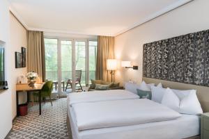 慕尼黑Parkhotel Rothof的酒店客房配有两张床和一张书桌