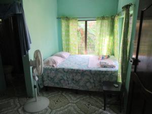 玉米岛Villy's Cottage的一间小卧室,配有床和窗户
