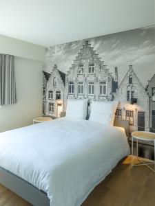 布鲁日安塔芮丝住宿加早餐旅馆的卧室配有白色大床和壁画。