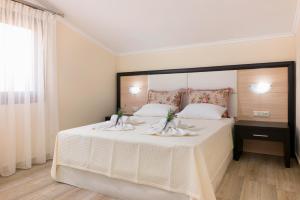 阿斯特里斯加戈斯一室公寓的一间卧室配有一张白色大床,床上有鲜花