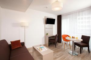 巴黎巴黎罗莎帕克斯公寓式酒店的客厅配有沙发和桌子