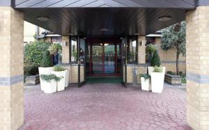 考文垂考文垂南柑橘可母帕斯酒店 的建筑入口,有门,有盆栽植物