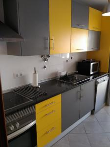 奥良casa da teresa的厨房配有黄色橱柜和炉灶烤箱