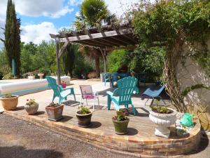 Vergt-de-BironLe Chalet Bleu的庭院设有椅子和种有植物的凉亭。