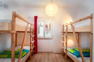纳扎雷Nazaré Hostel - Rooms & Dorms的客房设有三张双层床和一扇窗户。