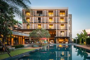 曼谷The Silver Palm Wellness Resort的享有带游泳池的建筑的外部景色