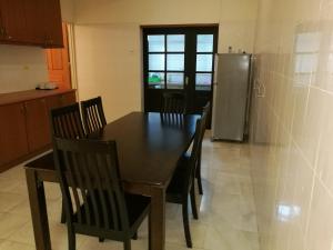 峇六拜槟城峇六拜维斯塔纳度假屋的厨房配有桌椅和冰箱。