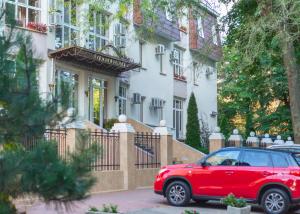敖德萨勒尔蒙托夫斯基酒店的停在房子前面的红色汽车