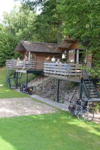 海尔伦Camping Hitjesvijver的树屋,外面有甲板和自行车