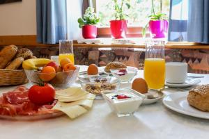 奥拉Garni Meinrad的一张桌子,早餐包括鸡蛋、面包和橙汁
