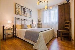 奥维罗A Feira Posada的一间卧室配有一张大床和一把椅子