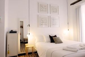 圣玛丽亚港圣玛丽亚赫斯派德斯酒店的一间白色卧室,配有两张床和凳子