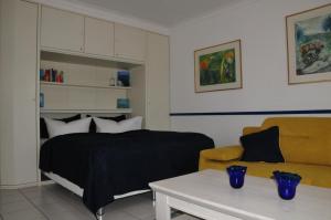 萨斯尼茨Ferienwohnung Anemone的一间卧室配有一张床、一张沙发和一张桌子