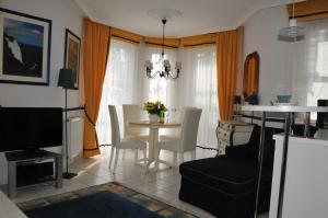 萨斯尼茨Ferienwohnung Anemone的厨房以及带桌椅的起居室。