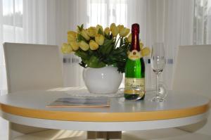 萨斯尼茨Ferienwohnung Anemone的一张桌子,上面放着一瓶葡萄酒和一瓶鲜花