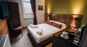威萧商务酒店的酒店客房设有一张大床和一张书桌。