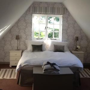 克拉德韦尔Gardeners Cottage的卧室配有白色的床和窗户