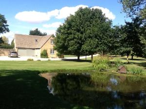 克拉德韦尔Gardeners Cottage的房屋前有池塘的房子