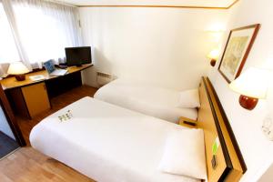 特里尼亚克钟楼圣纳扎尔特里纳克酒店的酒店客房配有两张床和一张书桌