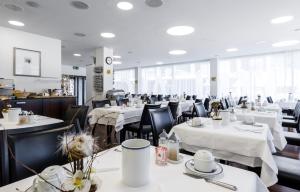 库尔ABC瑞士优质酒店的用餐室配有白色桌子和黑色椅子