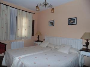 Cañete拉姆拉II号乡村民宿的一间卧室配有一张带白色床单的床和一扇窗户。
