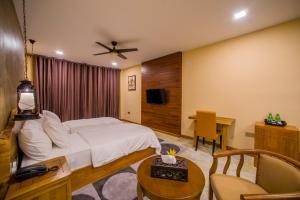 达拉万度基哈海滩酒店的酒店客房配有一张床、一张书桌和一台电视。