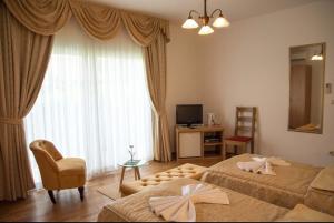 特罗吉尔库拉别墅 的一间卧室设有两张床、一把椅子和一个窗户。