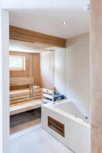 Mühldorf高萨湖白马宾馆的带浴缸和桑拿浴室的浴室