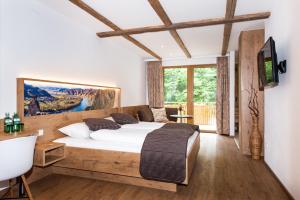 Mühldorf高萨湖白马宾馆的一间带大床和电视的卧室