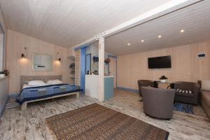克莱佩达Namelis poilsiui prie jūros的一间卧室配有一张床、一张沙发和一台电视